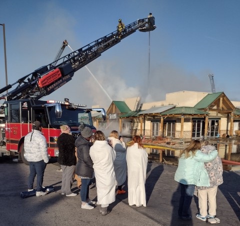People from the Seasons Spa watched and consoled each other as the firefighters continued to put out the fire.